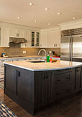 New kitchen with white shaker style perimeter and maple stained island.