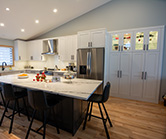 Pantry cabinets with some illuminated display space recessed into bump-out. Large island with seating for 4 and lots of storage