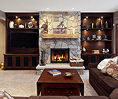 Beautiful new fireplace with stone, solid wood mantle, new cabinets, open shelving and speaker mesh doors to hide audio visual equipment 